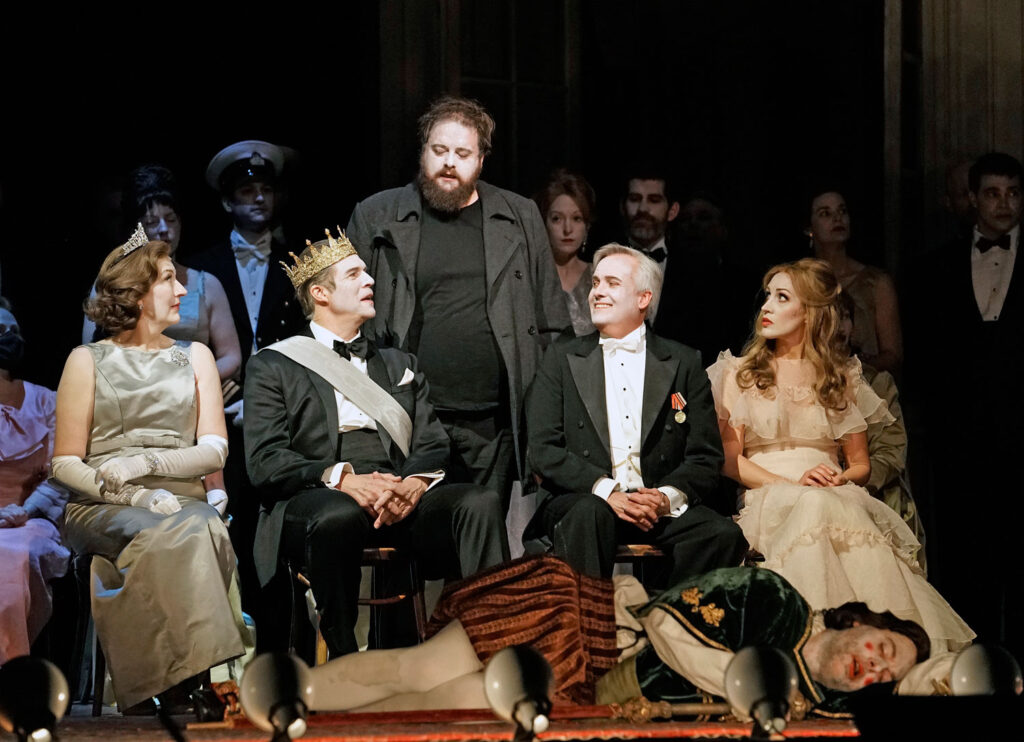 Sarah Connolly as Gertrude, Rod Gilfry as Claudius, Allan Clayton as Hamlet, Wiliam Burden as Polonius, Brenda Rae as Ophelia, and John Relyea (on floor) as a Player in Brett Dean's "Hamlet." Photo: Karen Almond / Met Opera