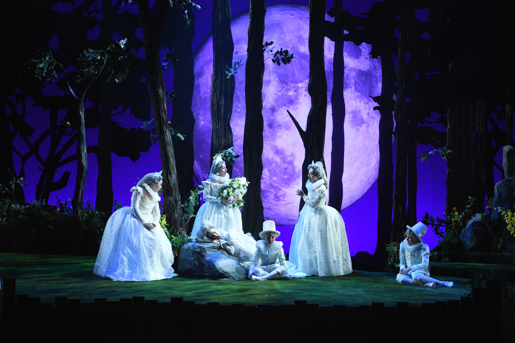 Naomi Brigell as Mustardseed, Sydney Mancasola as Tytania (asleep on rock), Véronique Fillouw as Peaseblossom, Emma Rothfield as Cobweb with members of the youth chorus